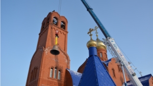 Установка купола и колокола над строящимся храмом